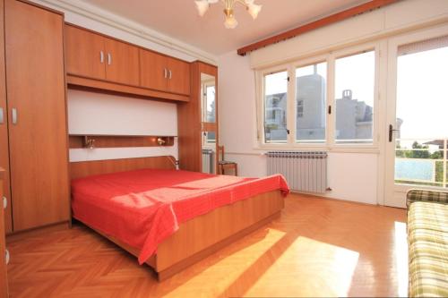 1 dormitorio con 1 cama con manta roja en Apartments with a parking space Lovran, Opatija - 7807, en Lovran