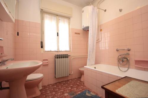 y baño de color rosa con lavabo, aseo y bañera. en Apartments with a parking space Lovran, Opatija - 7807, en Lovran