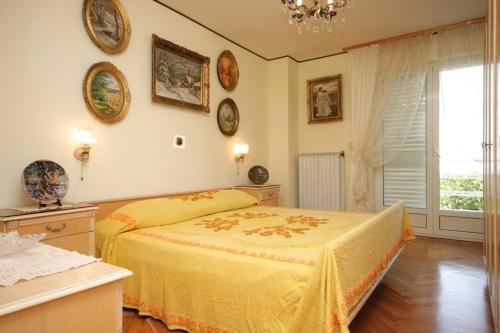a bedroom with a yellow bed and a window at Apartments with a parking space Icici, Opatija - 7822 in Ičići