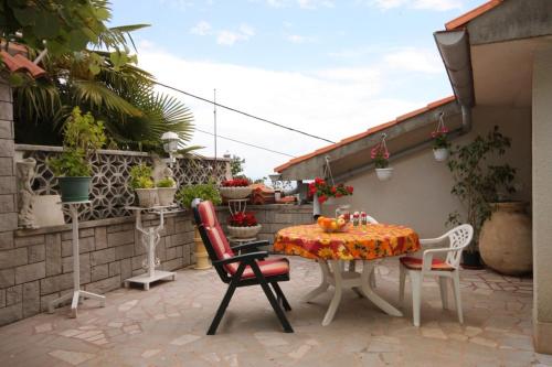 a patio with a table and chairs on a patio at Apartments with a parking space Icici, Opatija - 7822 in Ičići
