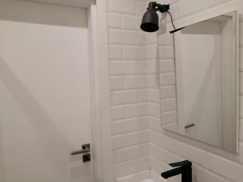 a white bathroom with a mirror and a sink at Paradise Space in Lisbon