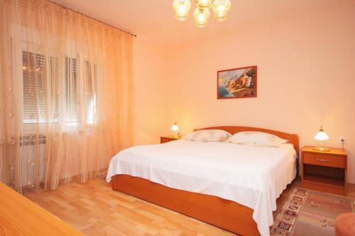 a bedroom with a white bed and a window at Apartments with a parking space Opatija - 7857 in Opatija