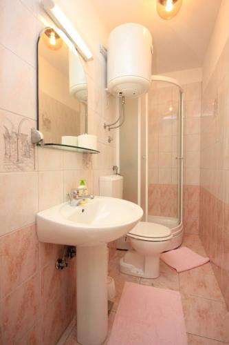 a bathroom with a sink and a toilet and a mirror at Rooms with a parking space Opatija - 7854 in Opatija