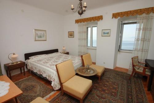 Schlafzimmer mit einem Bett, einem Tisch und Stühlen in der Unterkunft Apartments by the sea Opatija - Volosko, Opatija - 7911 in Opatija