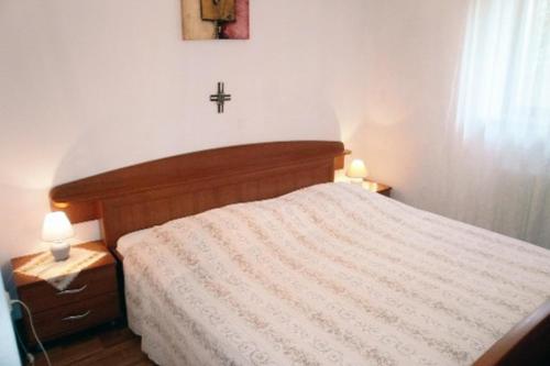 a bedroom with a bed with a cross on the wall at Apartments with a parking space Mali Losinj (Losinj) - 7940 in Mali Lošinj