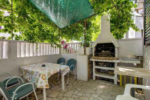 a patio with a table and an outdoor oven at Apartments with a parking space Mali Losinj (Losinj) - 8000 in Mali Lošinj