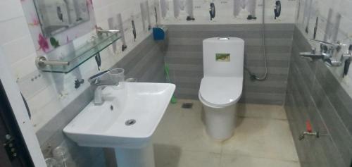 bagno con servizi igienici bianchi e lavandino di Green Hills Homestay 