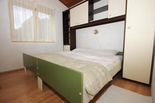 a bedroom with a green and white bed in a room at Apartments with a parking space Artatore, Losinj - 7938 in Cunski