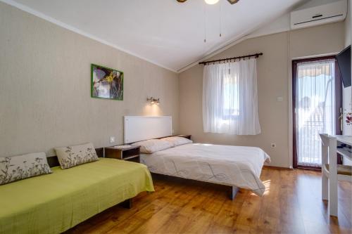 Čunski的住宿－Apartments by the sea Artatore, Losinj - 7934，一间带两张床的卧室和一台电视