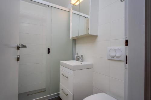 een witte badkamer met een toilet en een wastafel bij Apartments by the sea Artatore, Losinj - 7934 in Čunski