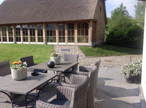 a patio with a table and chairs and a building at B&B Vallis Dyliae in Korbeek-Dijle