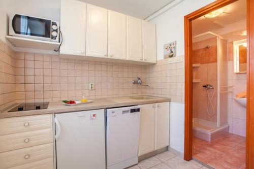 a kitchen with white cabinets and a white dishwasher at Apartments with a parking space Cres - 7983 in Cres