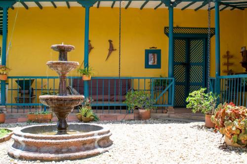 a fountain in front of a yellow building with plants at FINCA COCUYAL...todo un pesebre VIVO! in Rionegro