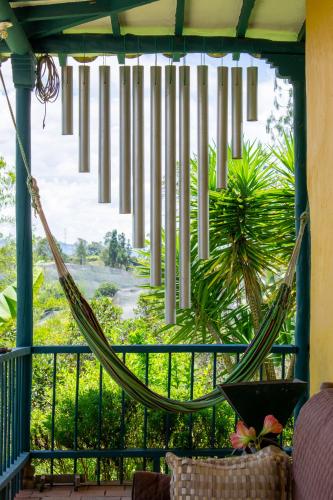 a hammock on a screened in porch with a view at FINCA COCUYAL Hospedaje típico paisa in Rionegro
