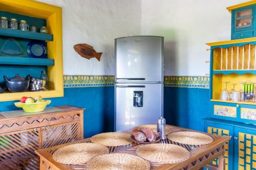 a kitchen with a table and a refrigerator at FINCA COCUYAL Hospedaje típico paisa in Rionegro