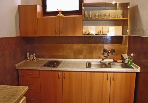 a kitchen with a sink and wooden cabinets at Apartments by the sea Postira, Brac - 9241 in Postira