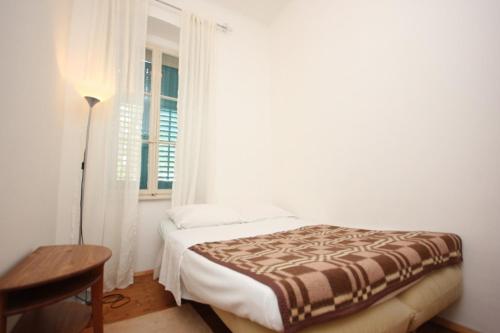 Schlafzimmer mit einem Bett, einem Tisch und einem Fenster in der Unterkunft Family friendly seaside apartments Moscenicka Draga, Opatija - 9242 in Mošćenička Draga