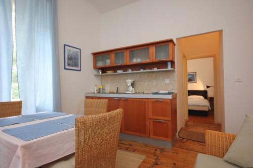 a kitchen with a table and a sink in a room at Family friendly seaside apartments Moscenicka Draga, Opatija - 9242 in Mošćenička Draga