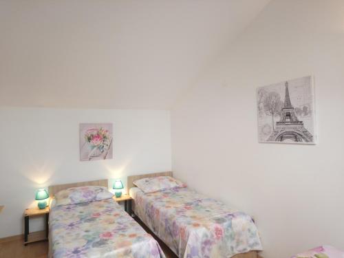 Apartments with a parking space Icici, Opatija - 7859 في إيتْشيتْشي: سريرين في غرفة مع صور على الحائط