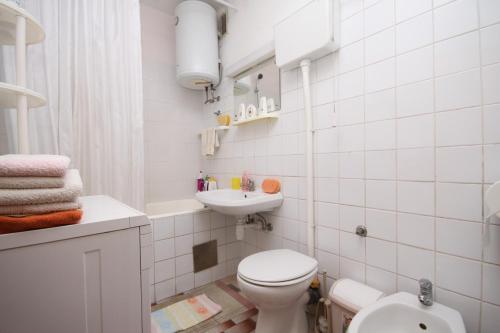 a white bathroom with a toilet and a sink at Rooms with WiFi Split - 9240 in Split