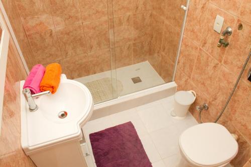 y baño con ducha, aseo y lavamanos. en Apartamento Lausanne en Río de Janeiro