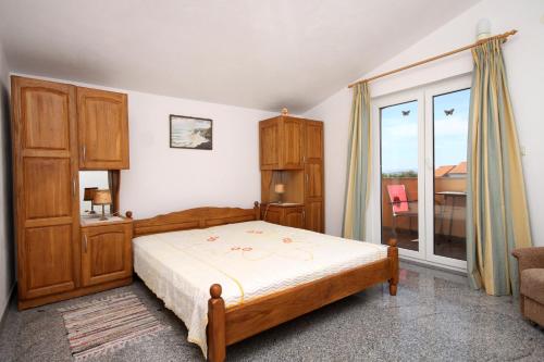 - une chambre avec un lit et une grande fenêtre dans l'établissement Apartments for families with children Kastel Stafilic, Kastela - 9211, à Kaštela
