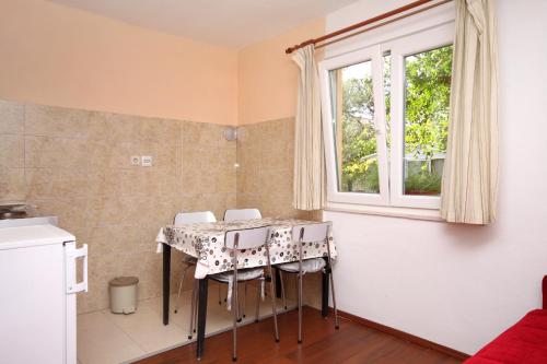 une cuisine avec une table et des chaises ainsi qu'une fenêtre dans l'établissement Apartments for families with children Kastel Stafilic, Kastela - 9211, à Kaštela