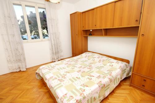 a bedroom with a bed and a cabinet and a window at Apartments by the sea Medvinjak, Korcula - 9268 in Korčula
