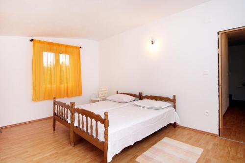 una camera da letto con un letto con lenzuola bianche e una finestra di Seaside holiday house Prigradica, Korcula - 9282 a Blato