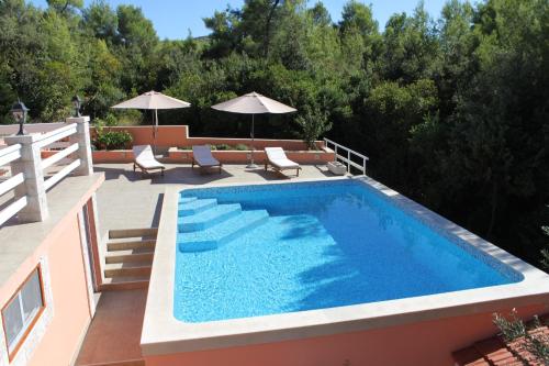 a swimming pool on the side of a house at Family friendly apartments with a swimming pool Smokvica, Korcula - 9161 in Smokvica