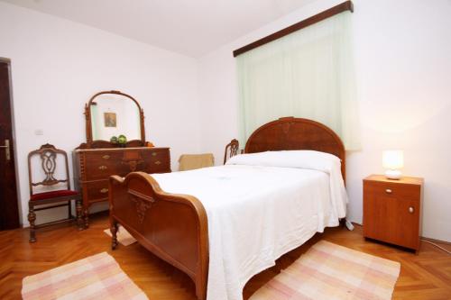 a bedroom with a bed and a dresser and a mirror at Family friendly apartments with a swimming pool Smokvica, Korcula - 9161 in Smokvica