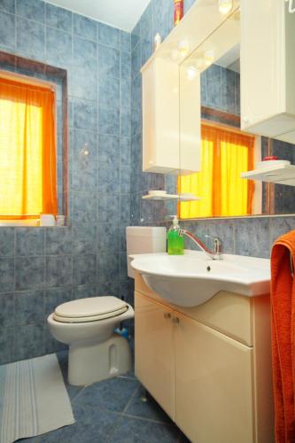 a bathroom with a white sink and a toilet at Family-friendly apartments with swimming pool Smokvica, Korcula - 9161 in Smokvica