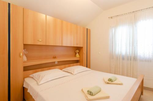 1 dormitorio con 1 cama con 2 toallas en Apartment Brna 9162b, en Smokvica
