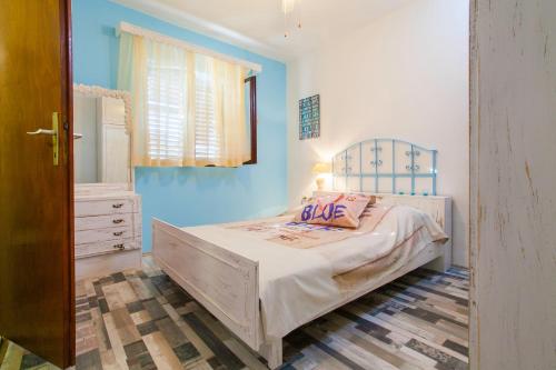 - une chambre dotée d'un lit avec un mur bleu dans l'établissement Apartments with a parking space Brna, Korcula - 9188, à Smokvica