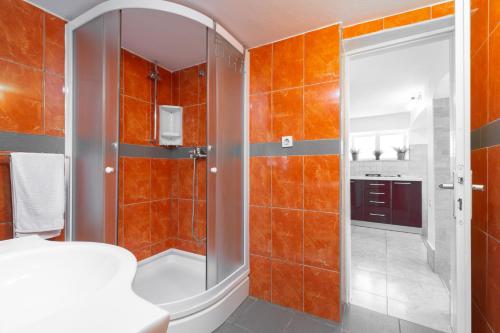 a bathroom with orange tiled walls and a shower at Seaside house for families with children Cove Stratincica, Korcula - 9265 in Vela Luka