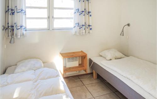 2 camas en una habitación con mesa y ventana en Knred, en Knäred