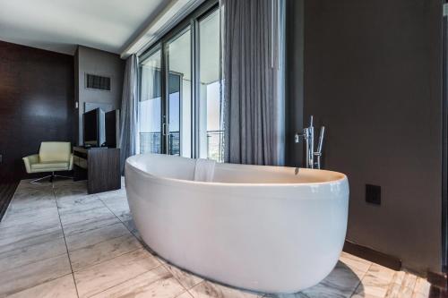 a large white tub in a bathroom with a window at Palms Place Hotel by Orgoto in Las Vegas