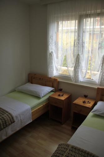 a bedroom with two beds and two windows at Apartments by the sea Kneza, Korcula - 9166 in Pupnat