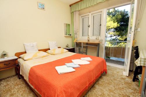 1 dormitorio con 1 cama con toallas en Apartments and rooms by the sea Lumbarda, Korcula - 9272, en Lumbarda