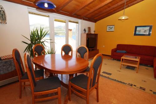 a living room with a wooden table and chairs at Apartments by the sea Kneza, Korcula - 9171 in Pupnat