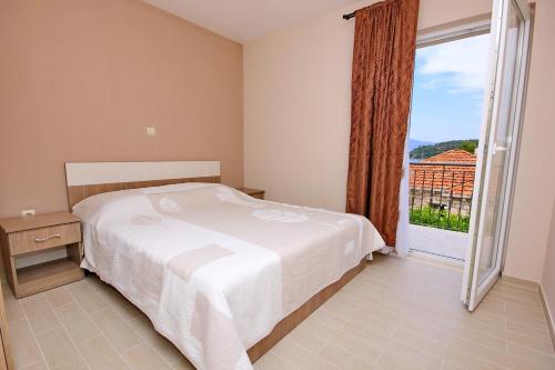 a bedroom with a bed and a large window at Seaside apartments with a swimming pool Lumbarda, Korcula - 9303 in Lumbarda