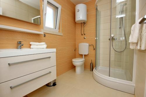 a bathroom with a toilet and a shower and a sink at Seaside apartments with a swimming pool Lumbarda, Korcula - 9303 in Lumbarda