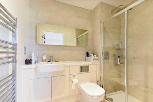 y baño con aseo, lavabo y ducha. en Lovely Luminous 3 Bed Flat, with secure Ev Parkng, en Londres