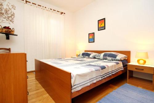 Apartments by the sea Lumbarda, Korcula - 9260 في لومباردا: غرفة نوم بسرير كبير مع اطار خشبي
