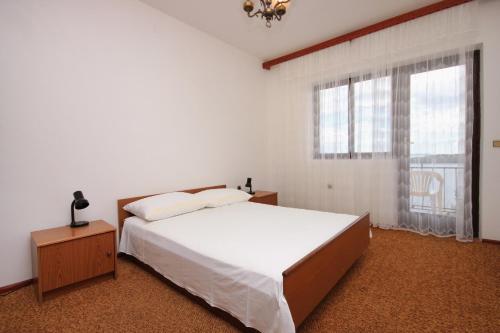 a bedroom with a bed and a large window at Apartments by the sea Prizba, Korcula - 9227 in Prizba