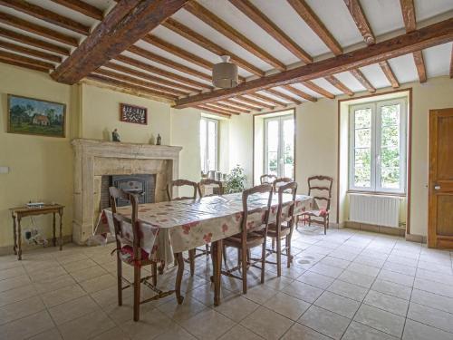une salle à manger avec une table et des chaises et une cheminée dans l'établissement Holiday Home in Normandy near Arromanches Beach, à Tracy-sur-Mer