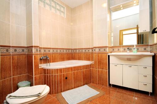 a bathroom with a toilet and a sink and a mirror at Apartments by the sea Lumbarda, Korcula - 9300 in Lumbarda