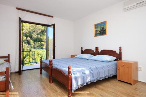 sypialnia z łóżkiem i dużym oknem w obiekcie Apartments by the sea Prigradica, Korcula - 9288 w mieście Blato