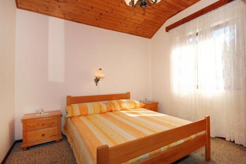 a bedroom with a bed and a window at Apartments by the sea Brna, Korcula - 9187 in Brna