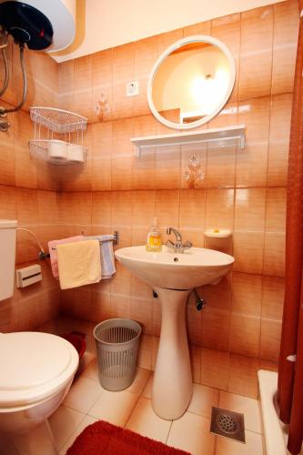 a bathroom with a sink and a toilet and a mirror at Apartments by the sea Brna, Korcula - 9187 in Brna
